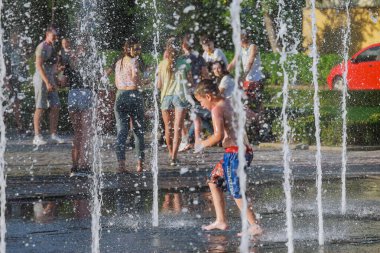 Uzhhorod, Ukrayna, 30 Haziran 2019: Çocuklar sıcak bir yaz günü çeşmede yıkanırlar.