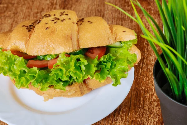新鲜的羊角面包 火腿和生菜放在咖啡店的木制桌子上 蔬菜羊角面包 — 图库照片