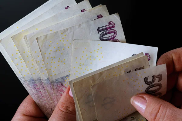 Çek parası siyah arka plandaki bir kadının elinde. 500 ve 100 banknotları.