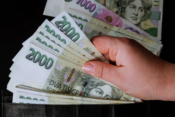 Çek parası siyah arka plandaki bir kadının elinde. 2000 'in banknotları.