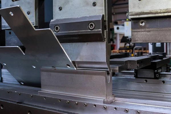 Bending sheet metal with a hydraulic bending machine at the factory.