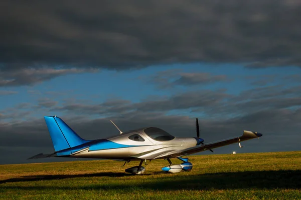 Lehké Malé Letadlo Travnatém Poli Pozadí Modrých Mraků — Stock fotografie
