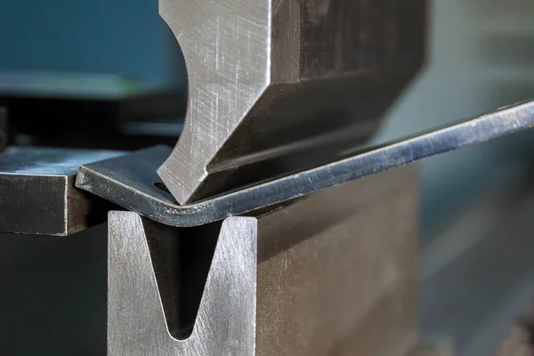 Bending sheet metal with a hydraulic bending machine at the factory.