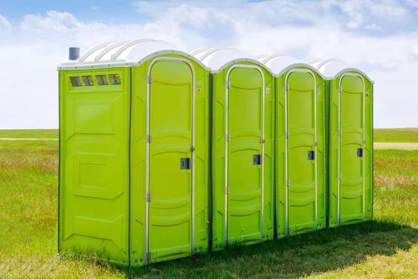 Tragbare Toilette auf dem Gras vor Wolkenhintergrund. — Stockfoto