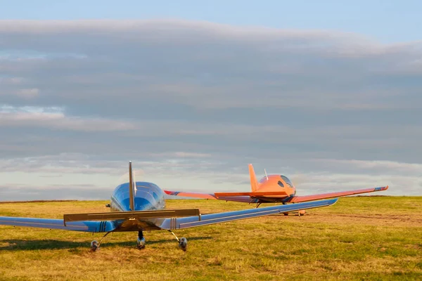 Rozmazat Malé Letadlo Travnatém Poli Pozadí Modrých Mraků — Stock fotografie