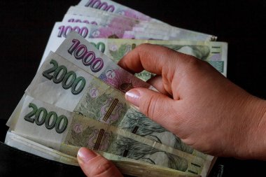 Çek parası siyah arka plandaki bir kadının elinde. Çek tacı siyah bir cüzdanda. 2000 'in banknotları.