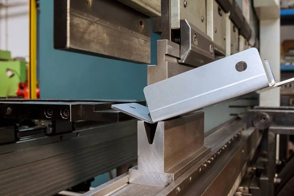 Bending sheet metal with a hydraulic bending machine at the factory. Bend tools, press brake punch and die.