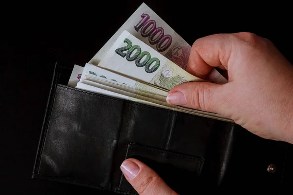 Çek parası siyah arka plandaki bir kadının elinde. Çek tacı siyah bir cüzdanda. 2000 'in banknotları.