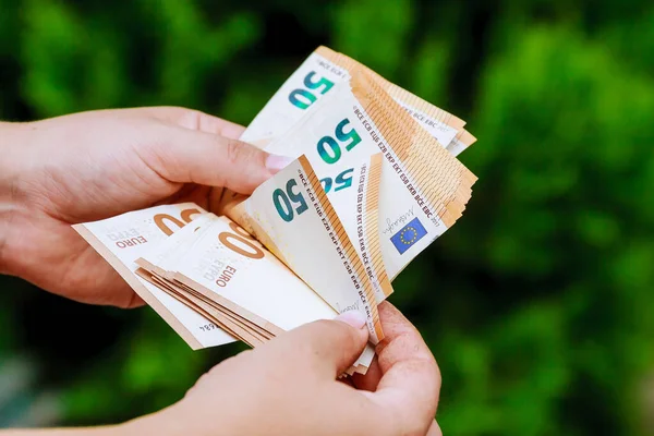 Adam bize avroluk banknotları sayıyor. Para saymak.