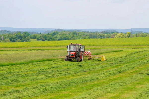 체코,스 쿠치, 2020 년 6 월 4 일: 얼마 전에 밭에서 자른 잔디에 회전용 천 조각이 달린 작은 트랙터. — 스톡 사진
