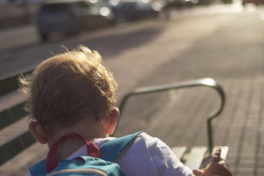 Küçük çocuk sırt çantasıyla kaçıyor.