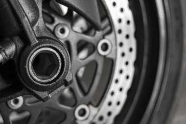 Motosiklet tekerleğinin ön dingilinin fren göstergesiyle yakın plan görüntüsü.