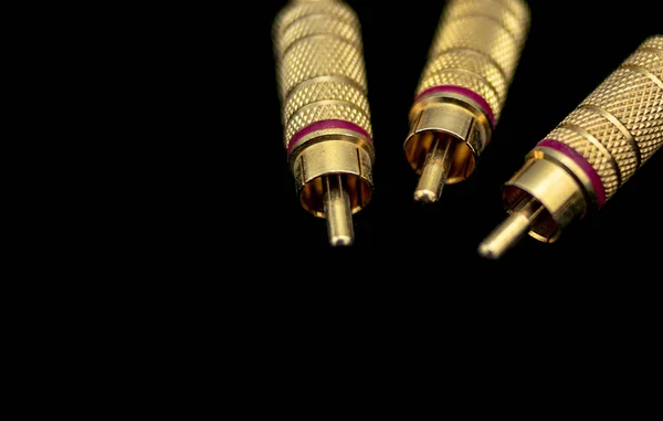 Três conectores macho metálicos e dourados tipo rca em primeiro plano — Fotografia de Stock