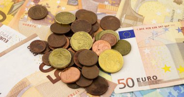 Elli ve yirmi avroluk banknotlar üzerine yığılmış bir avuç avro.
