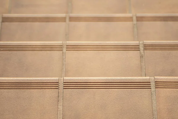 Stairs with terracotta clay tiles, joined with brown-colored cement, covering a patio with stairs in a house