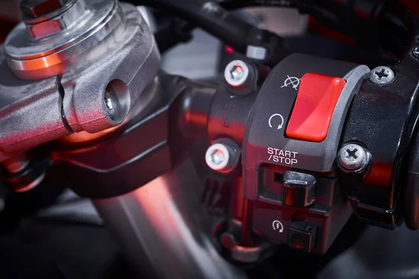 Ignition and starting system of a sports motorcycle located on the steering handle and safety lock