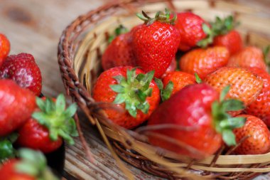 Tahta masanın üzerinde sulu çilekler var. Yaz atmosferi, yakın çekim, üst görünüm