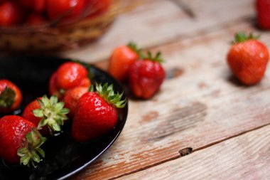 Ahşap masanın üzerinde mis kokulu, sulu çilekler var. Organik, GDO 'suz. Yaz atmosferi, yakın çekim, üst görünüm