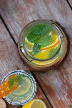 Limon, portakal, şeker ve naneden yapılan soğuk ev yapımı limonata. Süper lezzetli ve sağlıklı. Hadi bir deneyelim! Yaz atmosferi, yakın çekim, üst görünüm