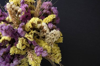 Statice çiçek üst görünümden siyah taş zemin üzerine