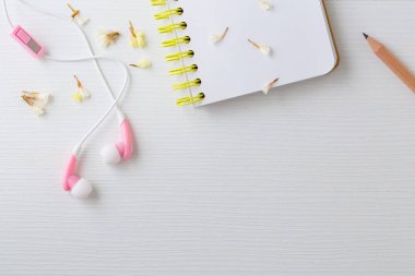 Kulaklık ve defter ile çiçek beyaz Resepsiyon arka planda, üstten görünüm