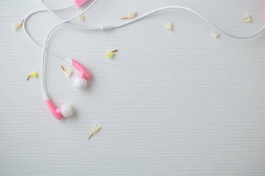 Beyaz ahşap masa arka planda, üstten görünüm alanı olan pembe kulaklık