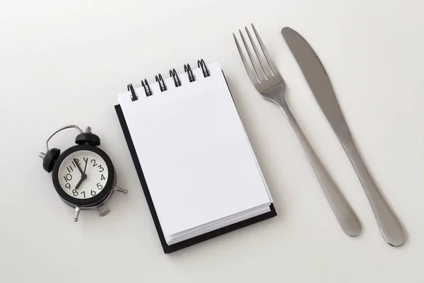 時計とメモ帳をフォークとナイフ 断続的な断食と減量計画コンセプト — ストック写真