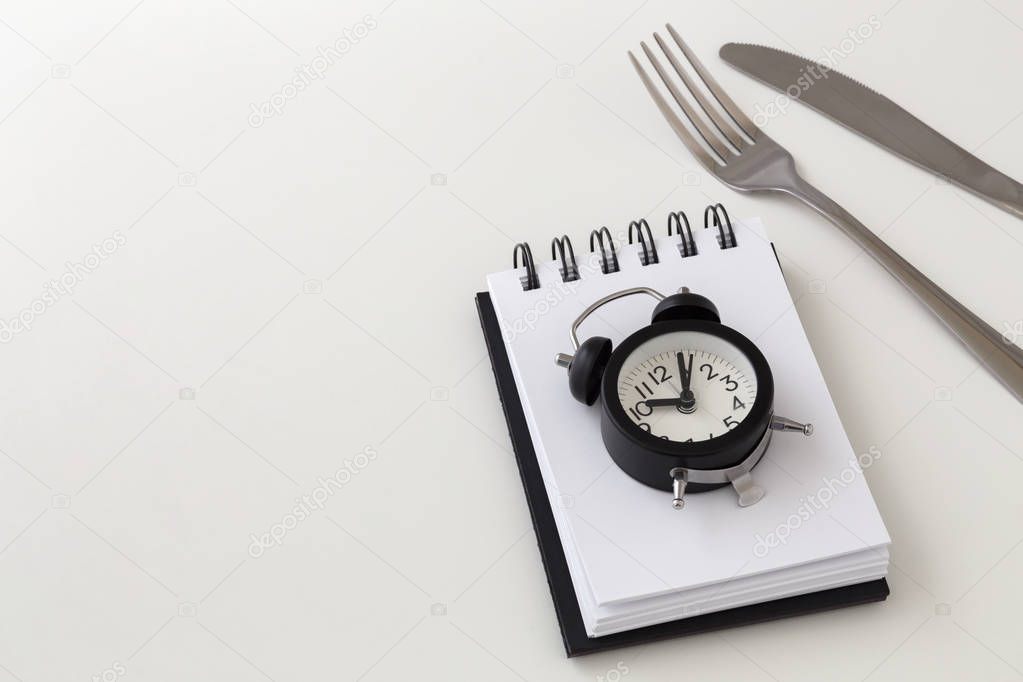 Clock with fork and knife, intermittent fasting and weight loss plan concept