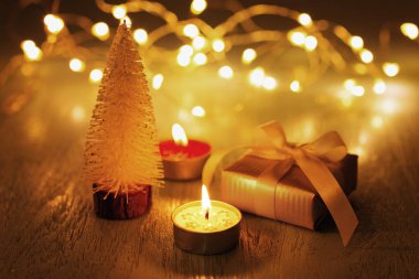 Noel mum ışığı ve bokeh ile koyu arka plan üzerinde hediye ve chrismas ağacıyla