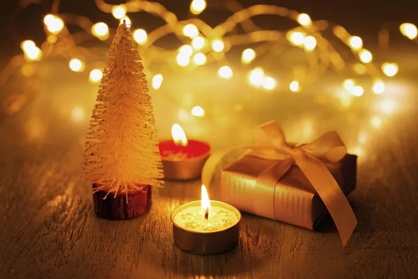 Noel mum ışığı ve bokeh ile koyu arka plan üzerinde hediye ve chrismas ağacıyla
