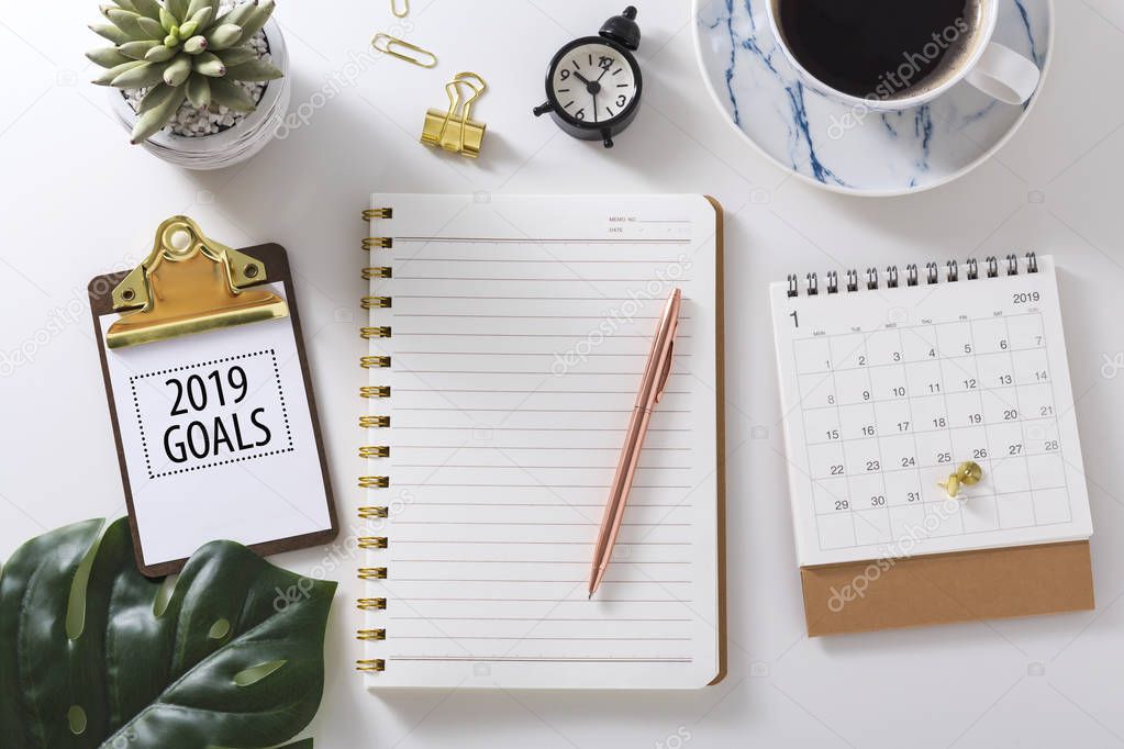 2019 goals text on clipboard with notebook,calendar and pen, flat lay