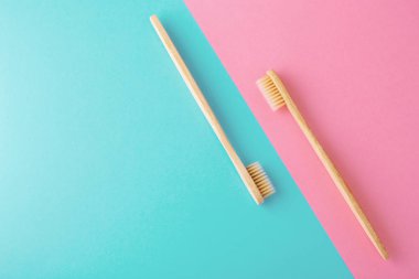 Pembe ve mavi arka plan üzerine ahşap diş fırçaları