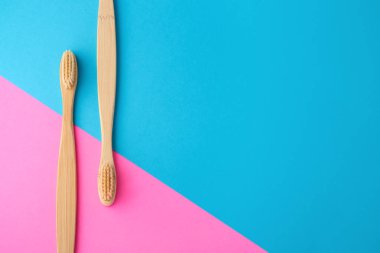 Pembe ve mavi arka plan üzerine bambu diş fırçaları
