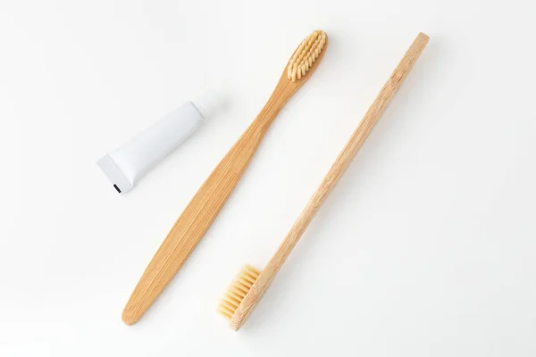 Wooden toothbrushes and toothpaste on white — Stock Photo, Image