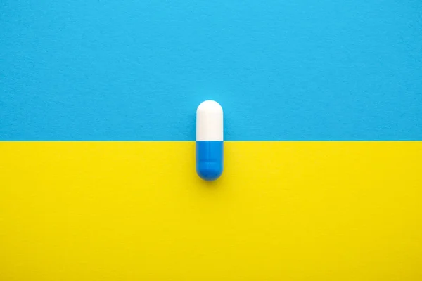 Medical pill on yellow blue background — ストック写真