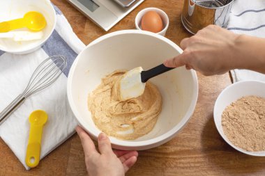 El ele tutuşma spatulası. Kurabiye pişirmek için malzemeleri kaseye karıştırma.