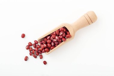 Tahta kepçe içinde Azuki kırmızı fasulyesi beyaz arka planda izole, üst manzara