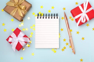 Mavi arka planda yıldız simli hediye kutuları olan Noel dilek listesi.