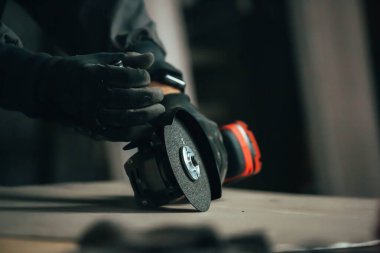 Elinde kırmızı öğütücü tutan bir işçi.