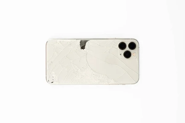 Telefonun arka kapağı kırılmış, beyaz arka planda izole edilmiş.