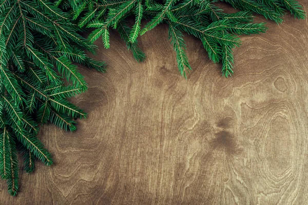 Vánoční rám s větvičkami izolované na dřevěném pozadí — Stock fotografie