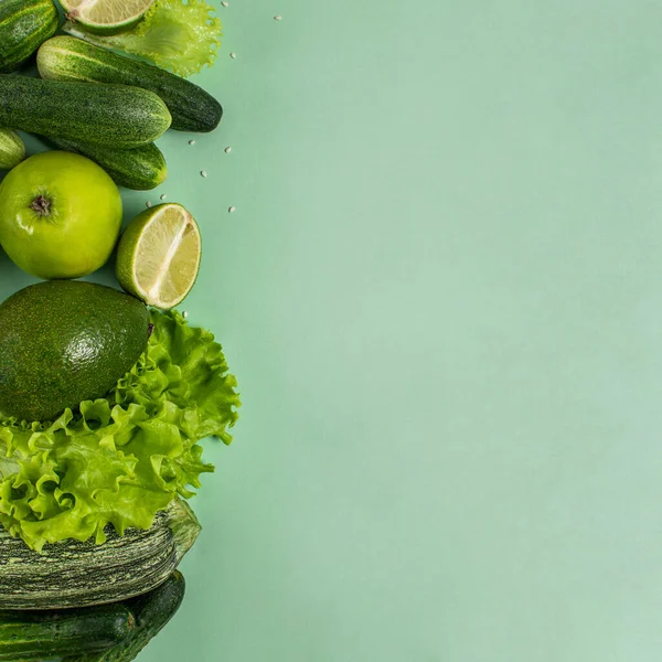 Organik çiğ sebze ve meyve kompozisyonu: kabak, salatalık. Avacado, elma, yeşil arka planda limon. Sağlıklı bir yaşam tarzı. Dengeli diyet. Yeşil detoks