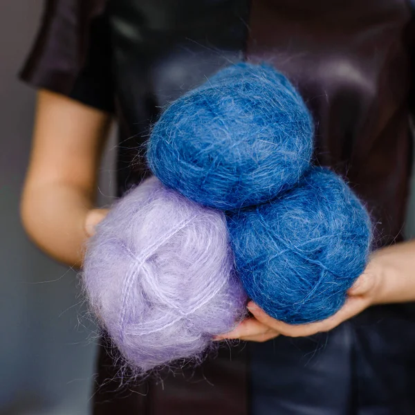 Kadın ellerinde çok renkli yün iplikçikler var. Alpaca, merino ipliği. Örgü ve örgü örmek için iplikler. Yaratıcılık ve hobiler.