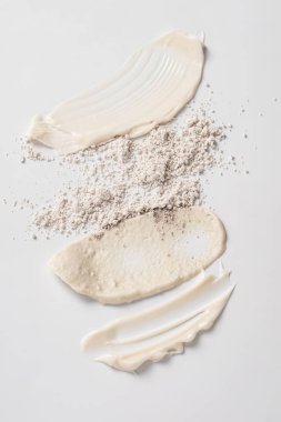 Beyaz arka planda beyaz kozmetik krem lekeleri. Cilt bakım losyonu serum doku örneği. Bir güzellik ürünü örneğine yakın çekim.