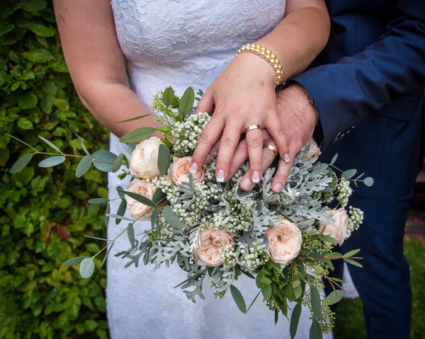 新婚者の手に花束を持って結婚指輪を — ストック写真