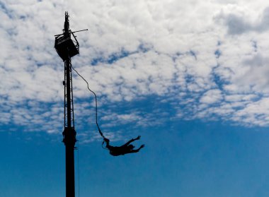 Mavi gökyüzünde kabarık bulutların üzerinde bungee jumping