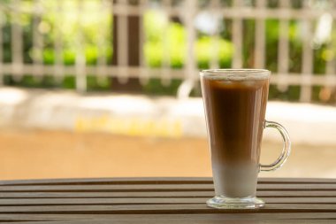 Ahşap masada buzlu latte ile yakın çekim. Seçici odak