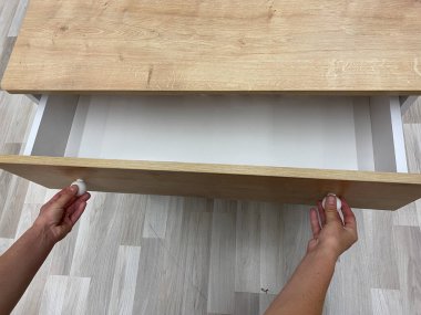  Çekmecenin sapını eliyle tutuyor.