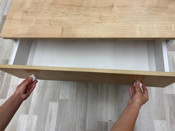  Çekmecenin sapını eliyle tutuyor.