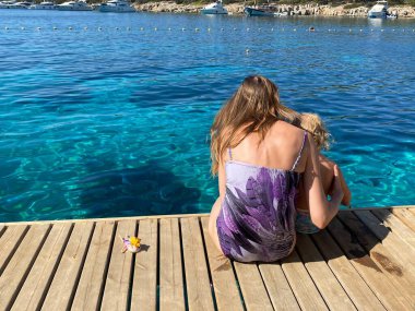 Annem ve babam tahta zeminde oturuyorlar.